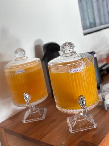 two glasses of orange juice on a wooden table at Pousada Beatriz - Búzios in Búzios