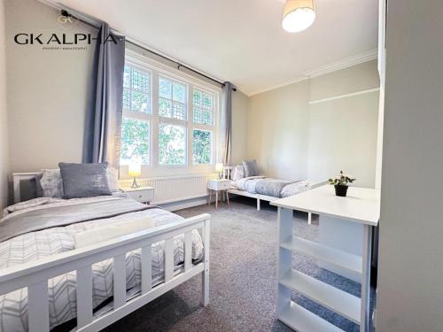 a bedroom with a white bed and a window at Modern 2-Bed Apartment with Wi-Fi & Parking Near Royal Berkshire Hospital & Reading Station in Reading