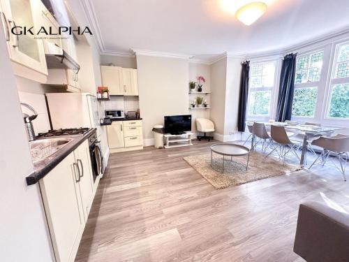 a kitchen and living room with a table and a dining room at Modern 2-Bed Apartment with Wi-Fi & Parking Near Royal Berkshire Hospital & Reading Station in Reading
