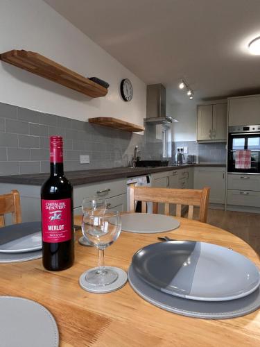a bottle of wine sitting on a table with a glass at An Cat Dubh - Luxury Apartment in Dingle