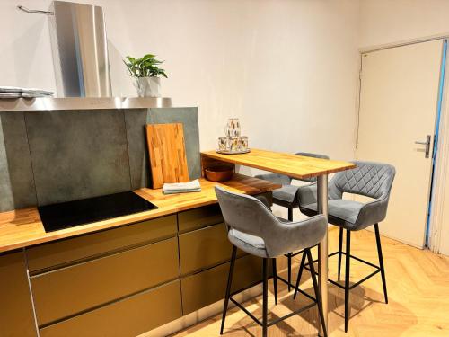 a kitchen with a counter with a table and chairs at Apartmán u Vetešnictví in Vítkovice