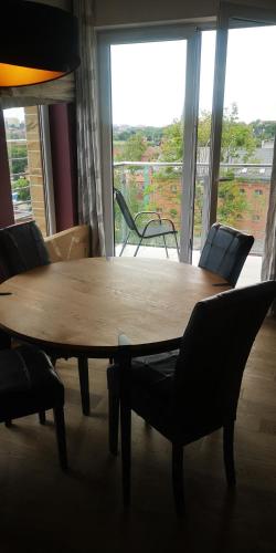 a wooden table and chairs in a room with a large window at Apartament Leśna nad jeziorem Długim in Olsztyn
