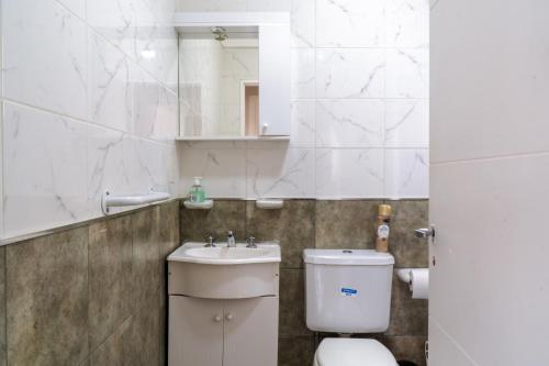 a bathroom with a toilet and a sink and a mirror at Femiba in El Calafate