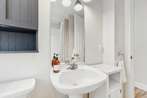 a white bathroom with a sink and a toilet at Rehoboth Beach Nirvana in Rehoboth Beach