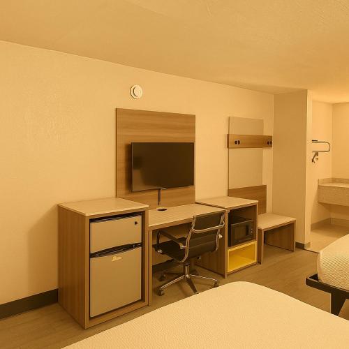 a room with a desk with a computer and a monitor at Economy Inn Little Rock in Little Rock