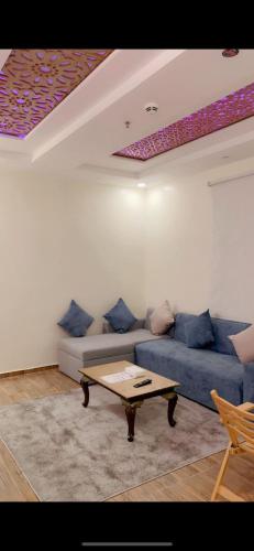a living room with a blue couch and a coffee table at منتجع شاطي الاحلام in Yanbu