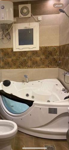 a bathroom with a bath tub and a toilet at منتجع شاطي الاحلام in Yanbu