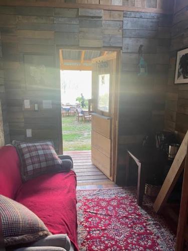 a room with a couch in a room with a door at Gracies Grotto Cabin in Powell River