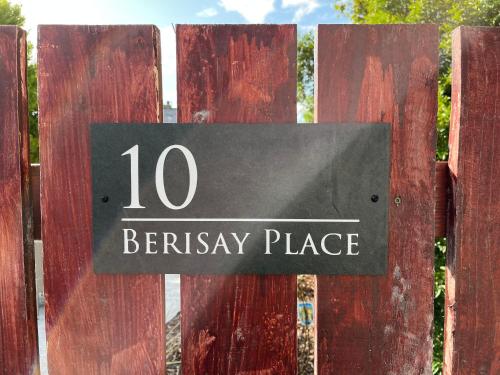 a sign on a wooden fence that reads ten berkeley place at 10 Berisay Place in Stornoway
