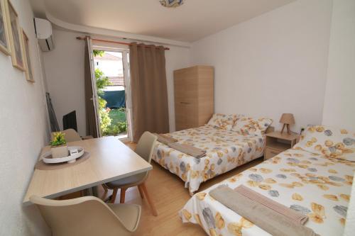 a small room with a bed and a table and a dining room at Ege Guest House in Ohrid