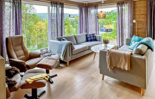 a living room with a couch and chairs and a large window at 4 Bedroom Gorgeous Home In Edland in Vågsli
