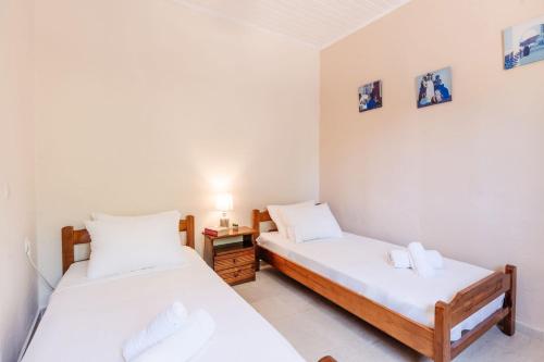 a bedroom with two beds and a night stand at Alexandros House in Agios Gordios Beach on Corfu in Agios Gordios
