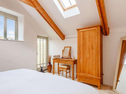 Un dormitorio con una cama y un escritorio con espejo. en 1 Bed in Falmouth 85826, en Gwennap