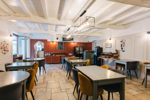 圣马洛Logis Hôtel la Grassinais Saint-Malo的一间有桌椅和厨房的餐厅