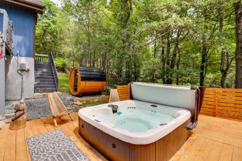 a jacuzzi tub sitting on a wooden deck at Hot Tub, Fire Pit and Barrel Sauna Poconos Abode in Long Pond