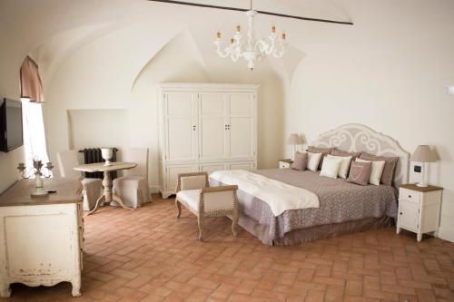 1 dormitorio con cama, mesa y lámpara de araña en Villa Sibilla, en Bubbio