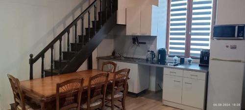 a kitchen with a wooden table and a staircase at Gite Artur in Bar-sur-Aube