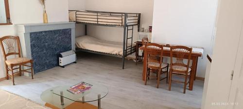 a room with a bunk bed and a table and chairs at Gite Artur in Bar-sur-Aube
