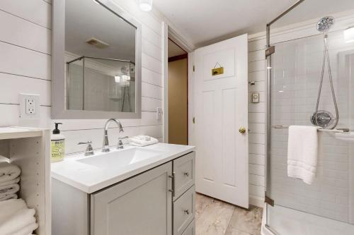 a white bathroom with a sink and a mirror at Reece Cottage in Ellsworth