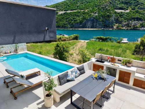a patio with a table and a swimming pool at Pool 4 Leisure Dubrovnik in Dubrovnik