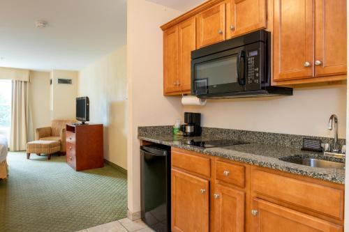 a kitchen with a sink and a microwave at White River Inn & Suites in White River Junction