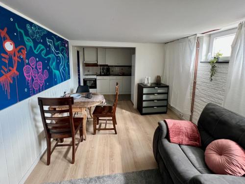 a living room with a table and chairs and a kitchen at The Abyss in Mölle