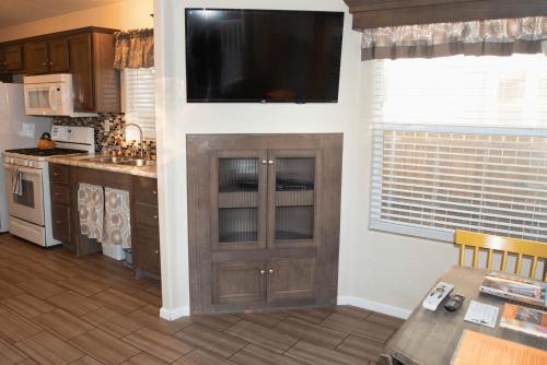 cocina con TV de pantalla plana en la pared en Juniper Grove Cabin #20, en Moab