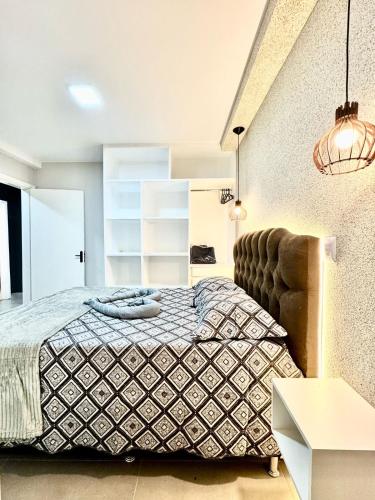 a bedroom with a bed and a chair at Incrível apartamento com suíte no centro da cidade in Formosa
