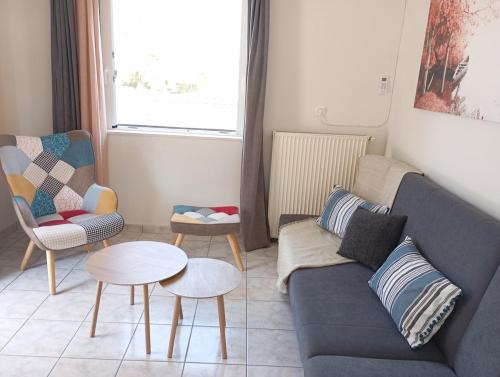 a living room with a couch and two chairs and a table at Sunset Dafnes beach in Patra