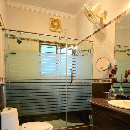 a bathroom with a shower and a toilet and a sink at Eden Grove Villa in Rawalpindi