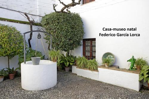 a building with a bunch of plants in front of it at Apartamento Fuente del Genil. in Fuente Vaqueros