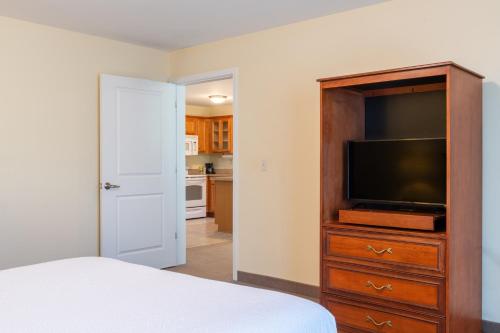 a bedroom with a bed and a flat screen tv at White River Inn & Suites in White River Junction