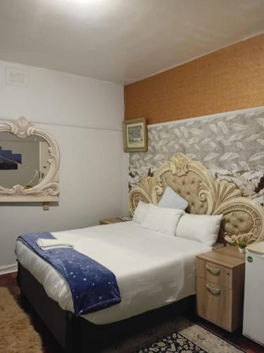 a bedroom with a large white bed and a mirror at Wonderful Guest house in Durban