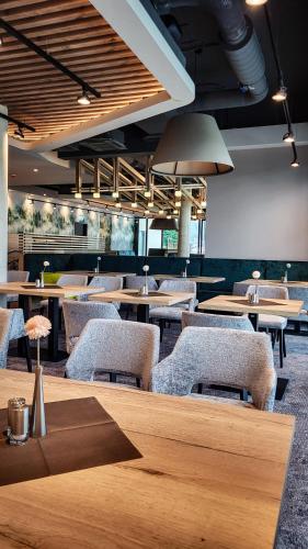 a restaurant with wooden tables and chairs and tablesearcher at Mountain View Hotel Willingen, BW Signature Collection in Willingen