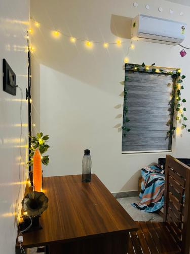 a room with a wooden table with lights on it at Harshis Shell in Varkala