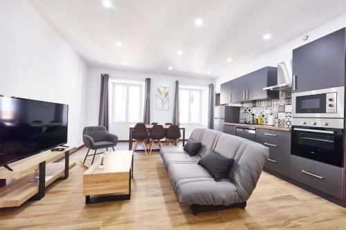 タンにあるTH 101 Appartement F3 spacieux 1 à 5 pers 1er étageのソファとキッチンのあるリビングルーム