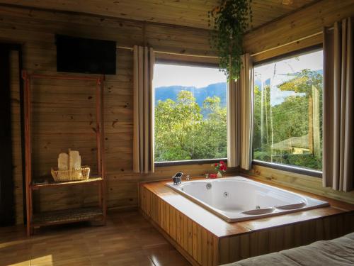 a bath tub in a room with a window at Morada da Pedra in Praia Grande
