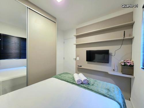 une chambre avec un lit et une télévision sur un mur dans l'établissement Apt Novo 2 Quartos 5 min do Centro e Av Cataratas, à Foz do Iguaçu