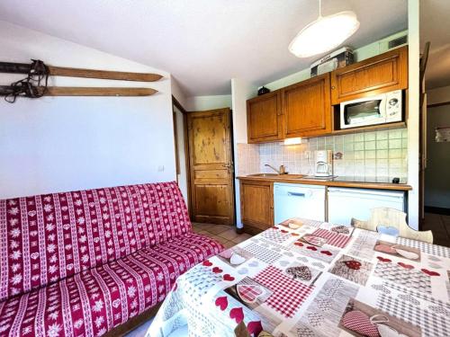 un salon avec un canapé rouge et une cuisine dans l'établissement Résidence Les Oursons - Appartement au pied des pistes, vue Mont-Charvin MAE-2394, à Notre-Dame-de-Bellecombe
