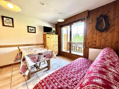 une chambre avec un lit, une table et une fenêtre dans l'établissement Résidence Les Oursons - Appartement au pied des pistes, vue Mont-Charvin MAE-2394, à Notre-Dame-de-Bellecombe