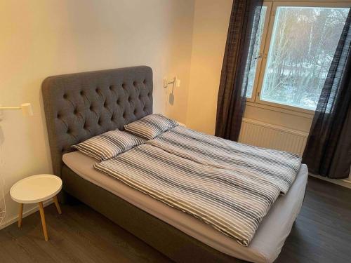 ein Schlafzimmer mit einem Bett mit einer großen Decke und einem Fenster in der Unterkunft Klintvägen 18 apartment 10 in Mariehamn