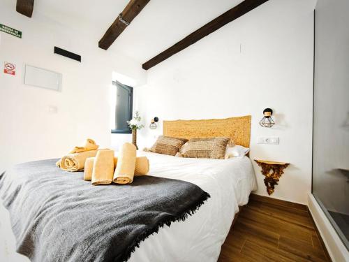 a bedroom with a large white bed with pillows at Casa rural La Cuca in Constantina
