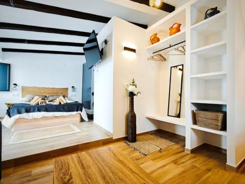 a bedroom with a bed and a vase with flowers at Casa rural La Cuca in Constantina