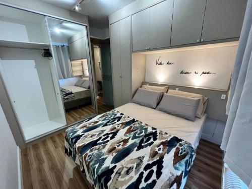 Un dormitorio con una cama y un espejo grande. en 1-Apto 1 dorm Barra Sul com VAGA, en Balneário Camboriú