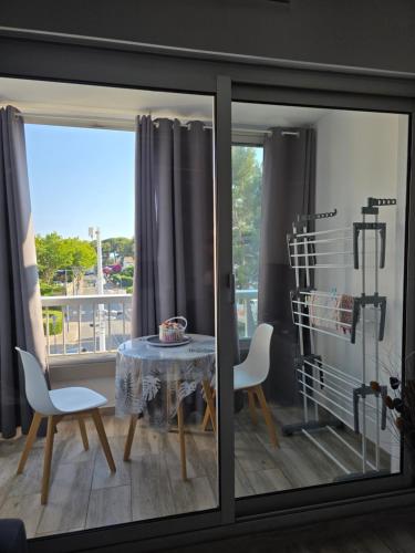 une salle à manger avec une table et des chaises sur un balcon dans l'établissement Saint Mandrier Pin Rolland Studio Climatisé 2 pers parking plage pinède, tout à pied, à Saint-Mandrier-sur-Mer