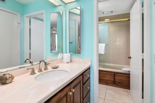 Un baño con lavabo, espejo y bañera. en North Breakers #408, en Saint Simons Island