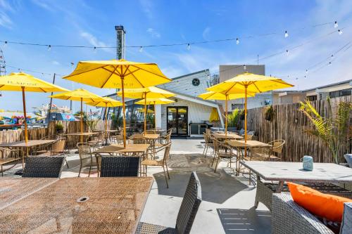 a patio with tables and chairs with yellow umbrellas at Aztec Ocean Resort in Seaside Heights