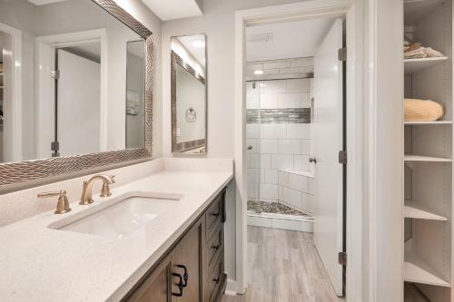 Un baño blanco con lavabo y ducha. en North Breakers #403, en Saint Simons Island
