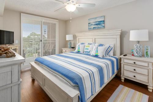 Un dormitorio blanco con una cama y una ventana. en North Breakers #402, en Saint Simons Island