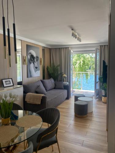 a living room with a couch and a table at Apartament MoLoo I in Ostróda